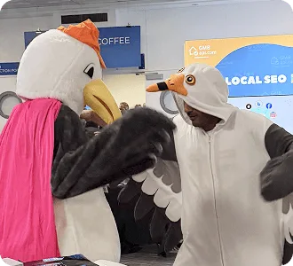 Dwie maskotki mew wchodzą w interakcję na stoisku Collaborator podczas BrightonSEO 2025.
