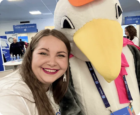 Członek zespołu Collaborator pozuje z maskotką BrightonSEO w kształcie mewy podczas wydarzenia w 2025 roku.