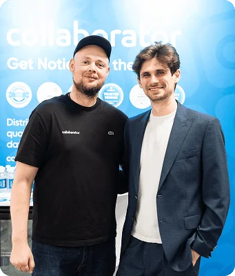 Założyciele Collaborator pozują razem na stoisku podczas BrightonSEO 2026.