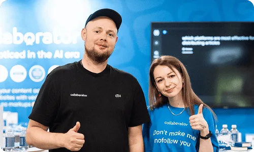 Dwóch członków zespołu Collaborator pozuje razem na stoisku podczas BrightonSEO 2026.